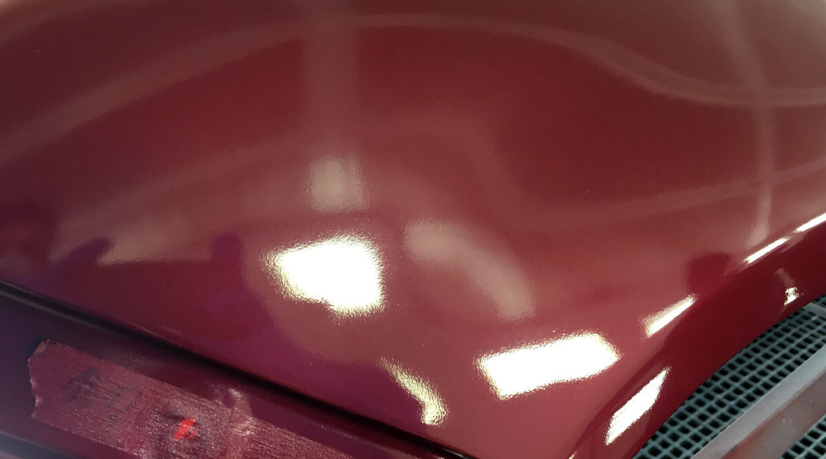 Bild på lackerad motorhuv med baslack innan klarlacken läggs